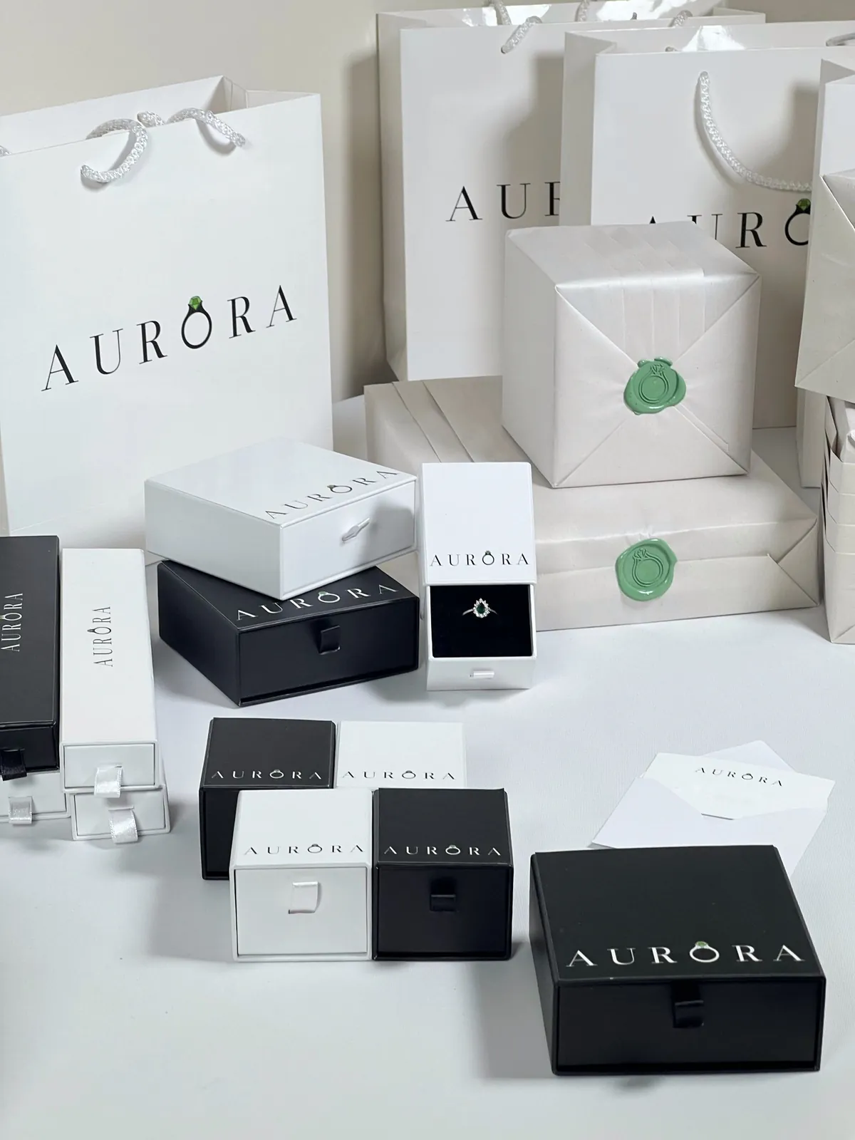 Aurora gift boxes in black and white with a green wax seal